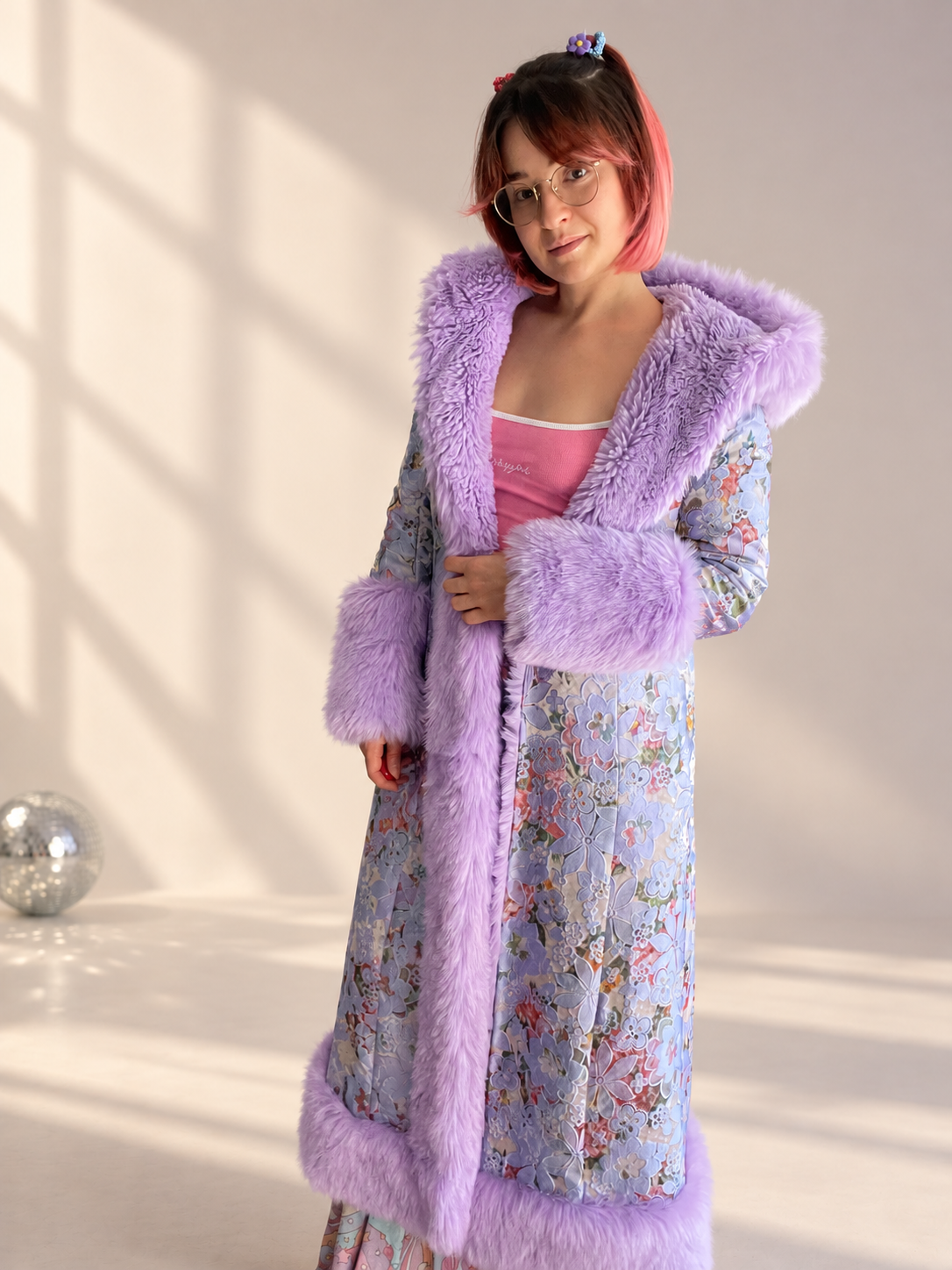 Model wearing the Lilac Princess full-length floral brocade coat with lilac faux fur trim and oversized cuffs