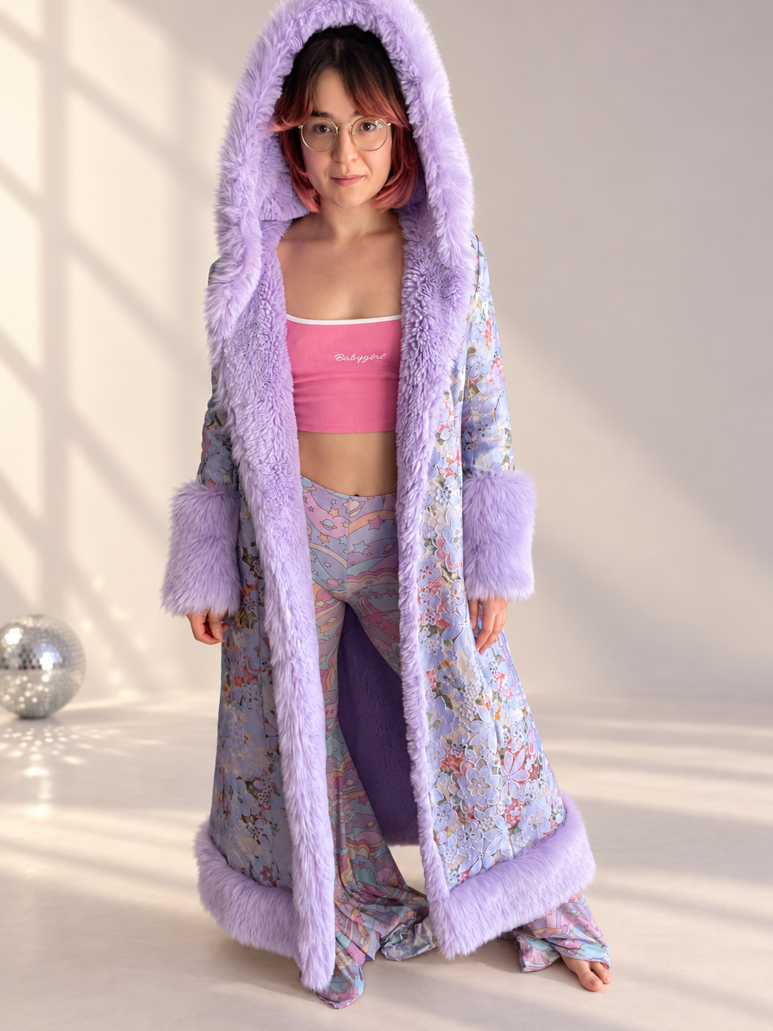 Front view of model wearing the Lilac Princess full-length floral brocade coat with lilac faux fur hood, cuffs, and trim